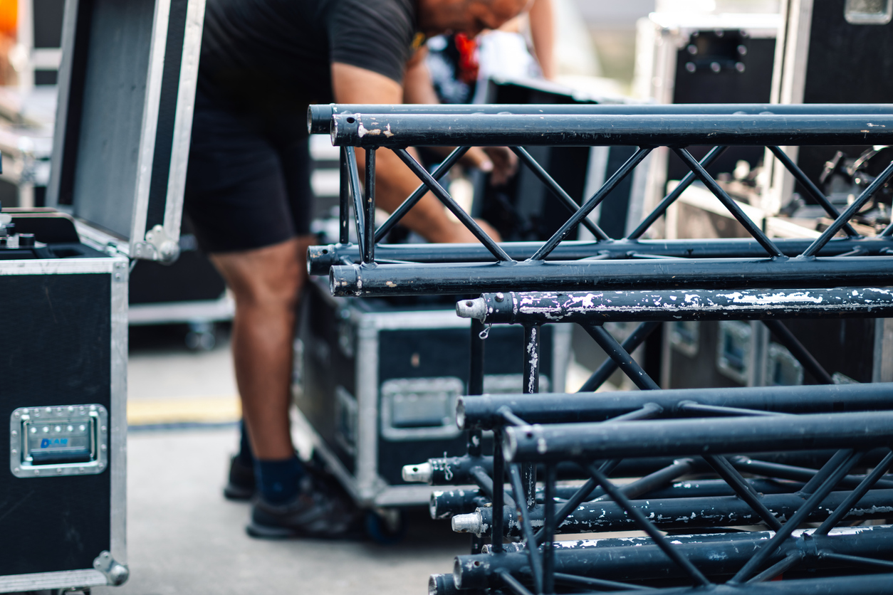 stage hand unloading truss for outdoor event